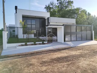 Fachada moderna de uma casa em Lajeado, Brasil, com grandes janelas de vidro.