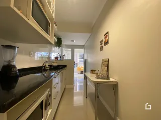 Foto de uma cozinha com armários e bancadas escuras.