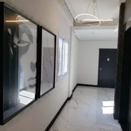 Hall de entrada com piso de mármore claro e paredes brancas.