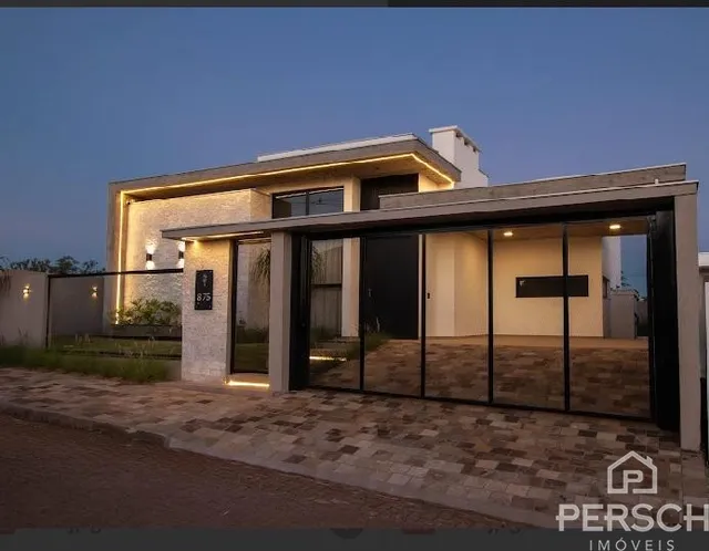 Fachada moderna de uma residência em Lajeado, Brasil, apresentando grandes painéis de vidro.