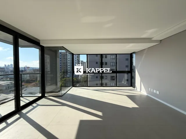 Sala de estar com grandes janelas que proporcionam uma vista panorâmica da cidade.