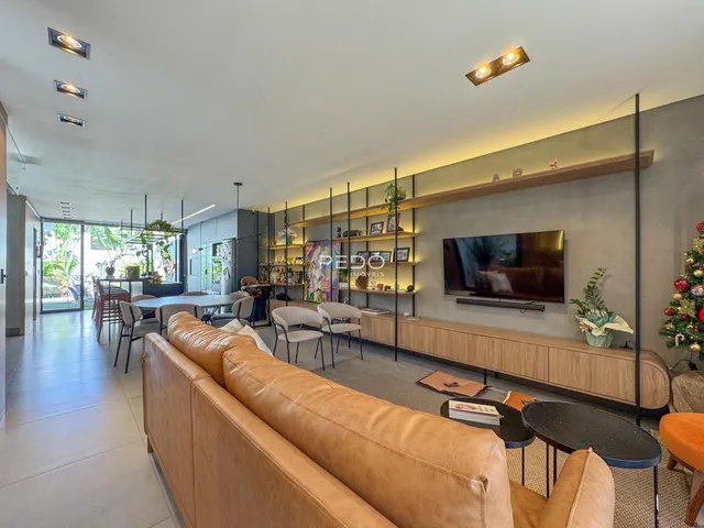 Sala de estar ampla com sofá e parede de TV em um apartamento.