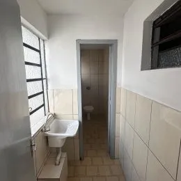 Um interior de banheiro com pia e vaso sanitário é visível na foto.