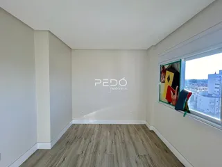 Sala de estar com piso de madeira clara e janela com vista da cidade.
