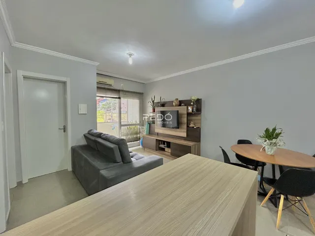 Sala de estar com sofá e móveis de madeira em um imóvel no Brasil.