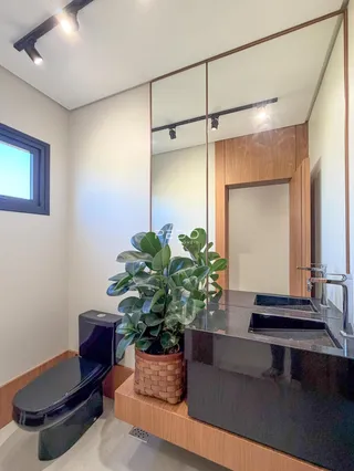 Foto de um banheiro moderno com bancada escura e decoração de madeira.