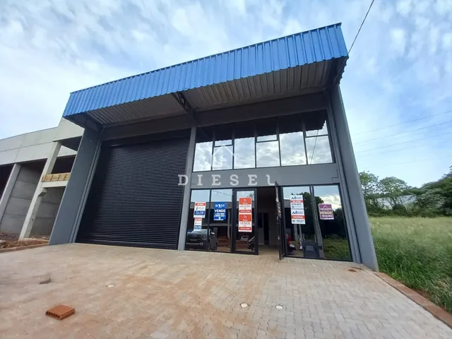 Fachada de um prédio comercial com telhado azul e porta de garagem.