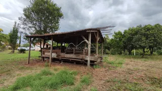 Estrutura rústica de madeira em um terreno gramado.