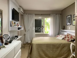 Quarto com cama e janela em ambiente claro.