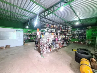 Imagem de um grande espaço industrial com estantes de roupas preenchidas.