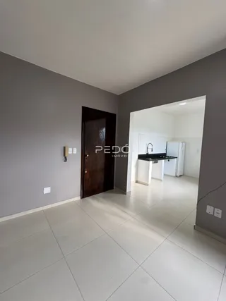 Interior de um corredor com porta de madeira escura e piso de cerâmica clara.