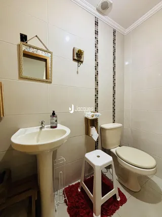Interior de um banheiro com pia e vaso sanitário em cerâmica.