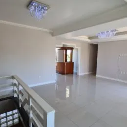 Ambiente interno com piso claro e armário de madeira na parede.