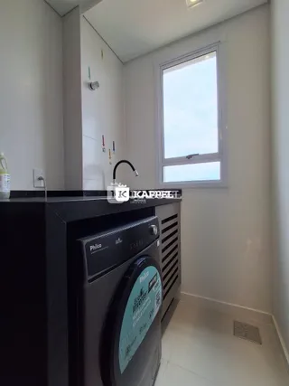 Foto de uma área de lavanderia com máquina de lavar roupa.