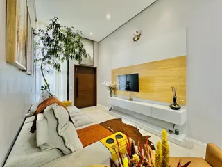Sala de estar moderna com sofá e televisão em um apartamento no Brasil.