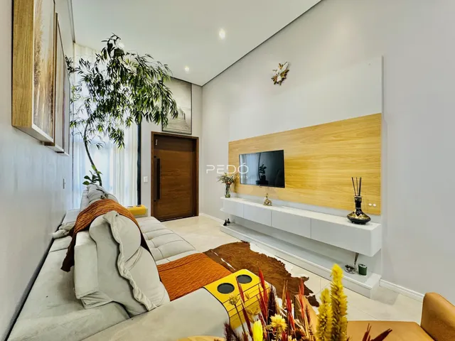 Sala de estar moderna com sofá e televisão em um apartamento no Brasil.