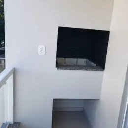 Parede branca com uma tela escura visível na parede.