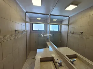 Foto de um banheiro com revestimento de azulejos e box de vidro.