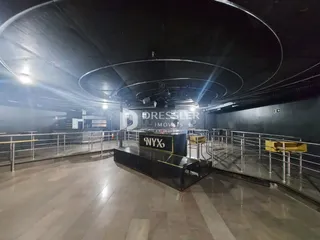 Vista interna de um espaço com teto curvo e grades metálicas.