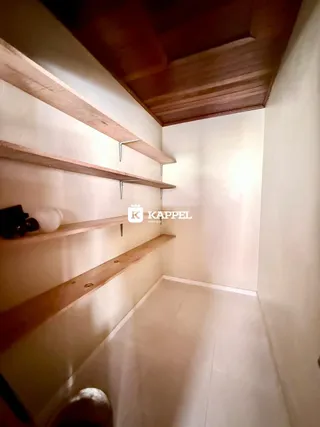 Hall de corredor com prateleiras de madeira e teto de madeira.