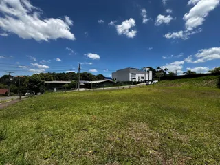 Vista aérea de um terreno com gramado e edifícios ao fundo.