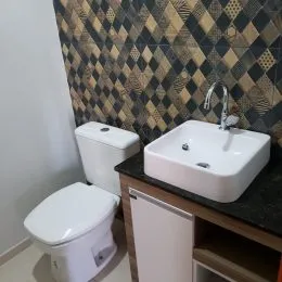 Foto de um banheiro mostrando um vaso sanitário e uma pia.