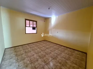 Uma foto interna de um cômodo com piso de cerâmica e paredes amarelas.