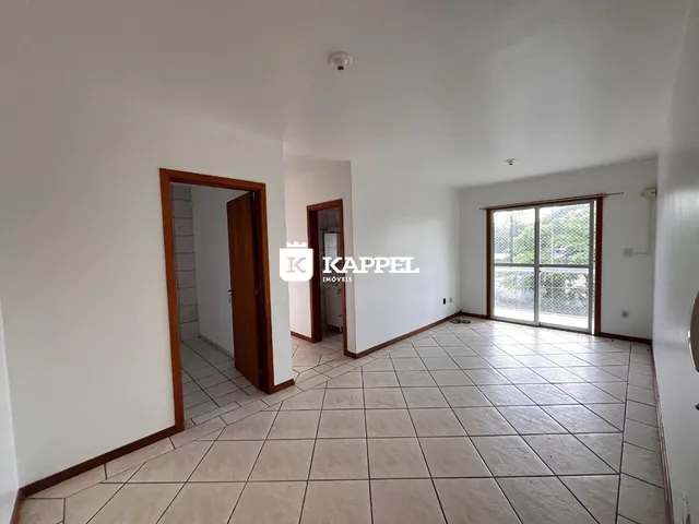 Uma sala ampla com piso de cerâmica e portas de madeira.