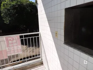 Parede branca com revestimento cerâmico e uma abertura escura em uma propriedade.