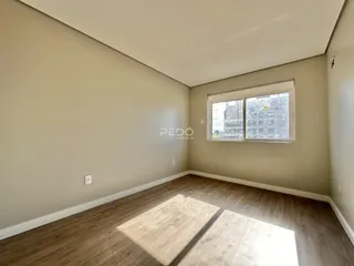 Sala de estar com piso de madeira e janela.