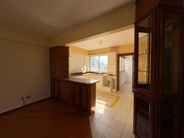 Sala de estar com cozinha integrada e armários de madeira.
