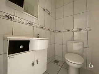 Banheiro com revestimento cerâmico nas paredes e piso.