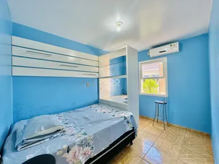 Quarto azul com cama e armário em um imóvel no Brasil.