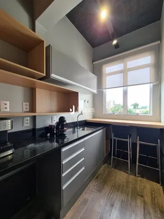 Vista da cozinha moderna com armários e piso de madeira.