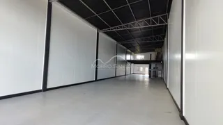 Hall de passagem com paredes brancas e teto estrutural exposto.