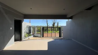 Uma foto de um corredor interno mostrando uma abertura para um pátio externo cercado por uma grade.