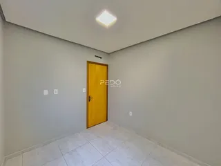 Corredor com porta amarela na entrada da sala.