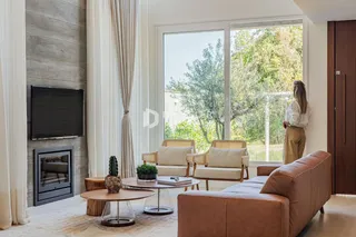 Sala de estar moderna com grandes janelas que oferecem vista para o exterior.