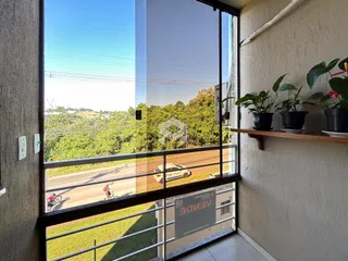 Vista da janela de uma residência em Lajeado, Brasil, mostrando uma área externa verde.