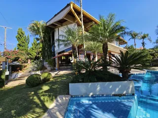 Fachada de uma residência com piscina e jardim em Lajeado.