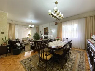Sala de jantar com móveis de madeira e piso de madeira em uma residência.