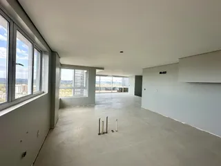 Imagem de um espaço interno amplo com piso de concreto.