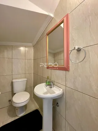Foto interna de um banheiro com azulejos brancos e louças sanitárias.