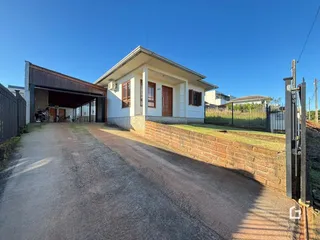 Fachada de uma casa em Lajeado, Brasil, com muro de tijolos e entrada de garagem.