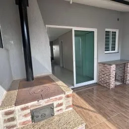 Vista parcial de uma área comum com revestimento de tijolos e piso de madeira.
