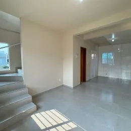 Foto de um corredor interno com piso claro.