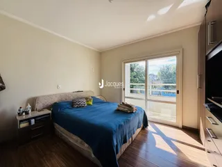 Quarto com cama e porta de vidro de acesso ao exterior.