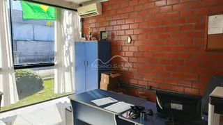 Sala de estar com parede de tijolos vermelhos e janela grande.