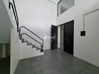 Vista interna de um corredor com escadaria e portas em uma residência.