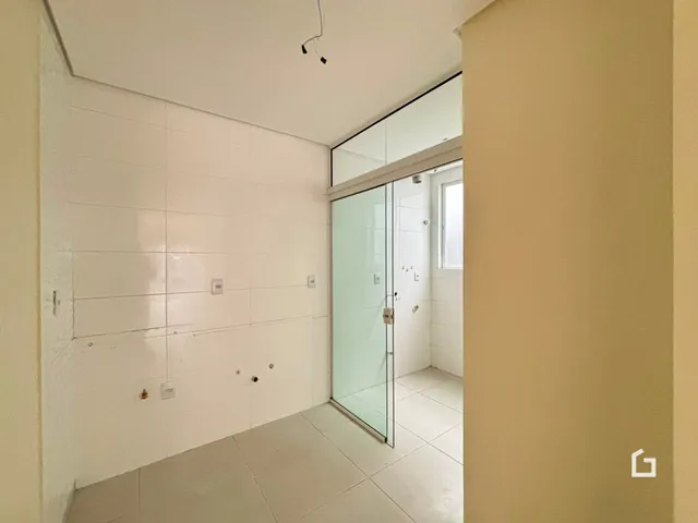 Hall de entrada com paredes brancas e piso claro.